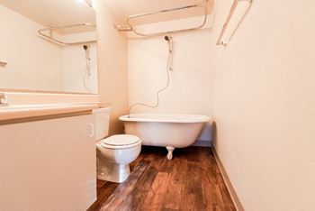 A bathroom with a toilet and a bath tub and a sink
